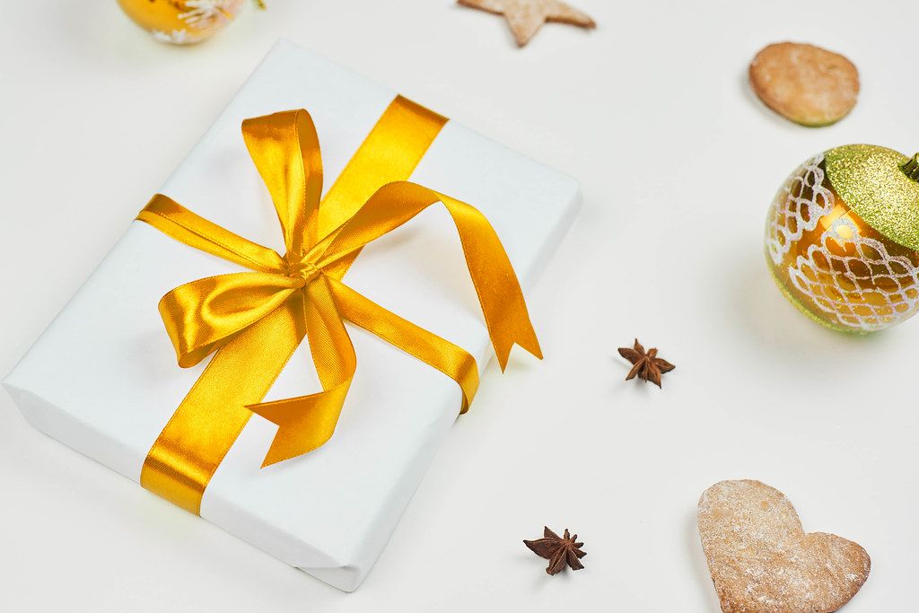 Überraschungsfilm 1 Bild von einem Geschenk mit weihnachtlicher Dekoration nebenbei.